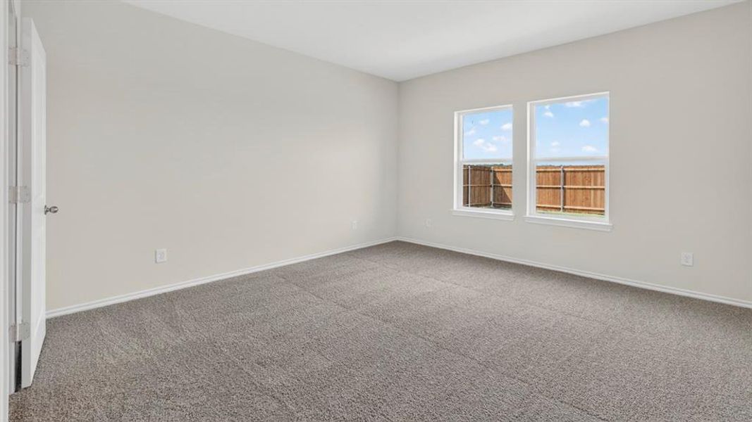 Spacious room featuring neutral carpeting, light-toned wall paint, white baseboards, and two window openings