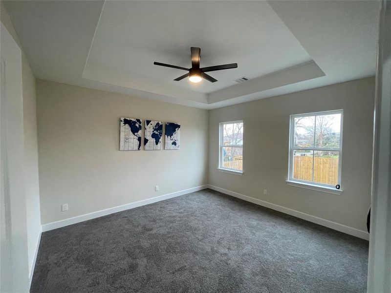 Master bedroom with tray ceiling and remote controled ceiing fan.