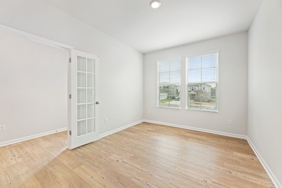 A room with a wood floor and a white door. A room with a wood floor and a white door.