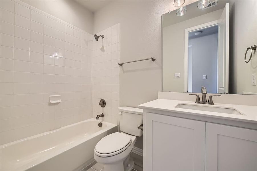 Full bathroom with vanity, toilet, and tiled shower / bath