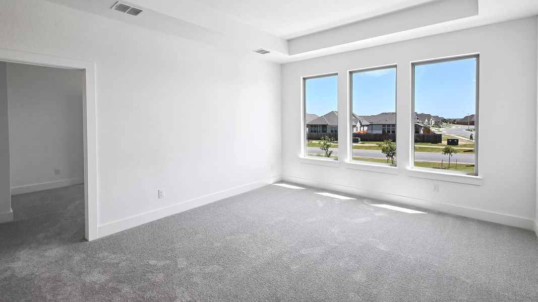 Carpeted spare room featuring baseboards and a residential view Carpeted spare room featuring baseboards and a residential view