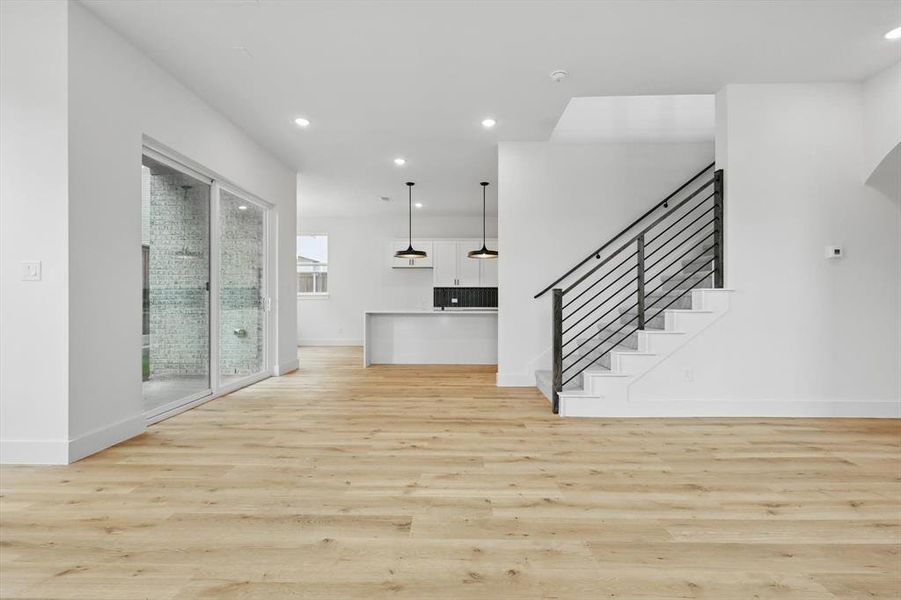 Unfurnished living room featuring light wood-type flooring, baseboards, and recessed lighting