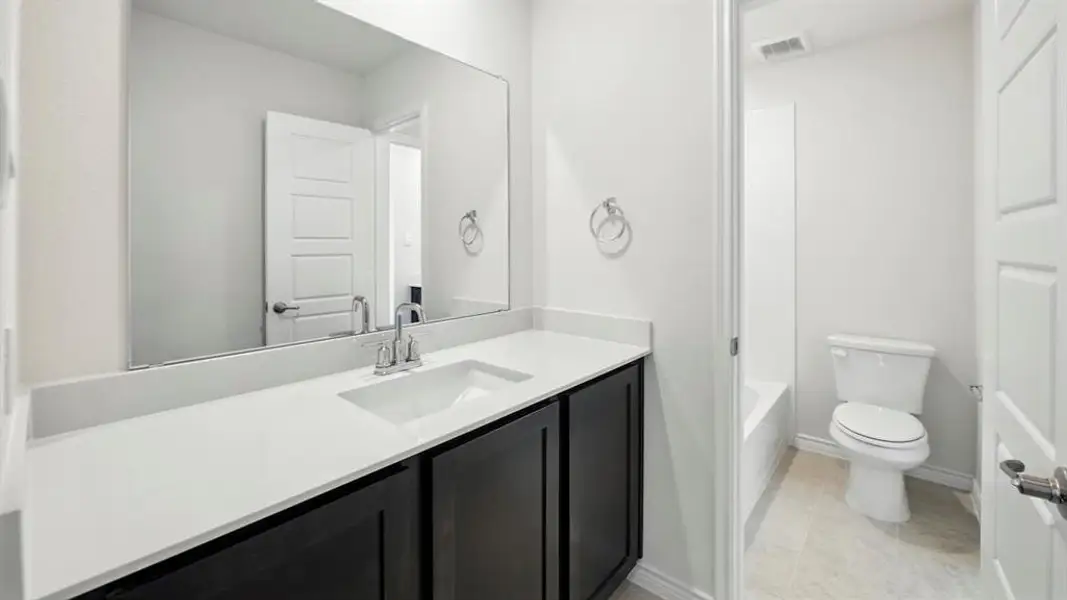 Full bath featuring vanity, light tile patterned floors, and bathing tub / shower combination