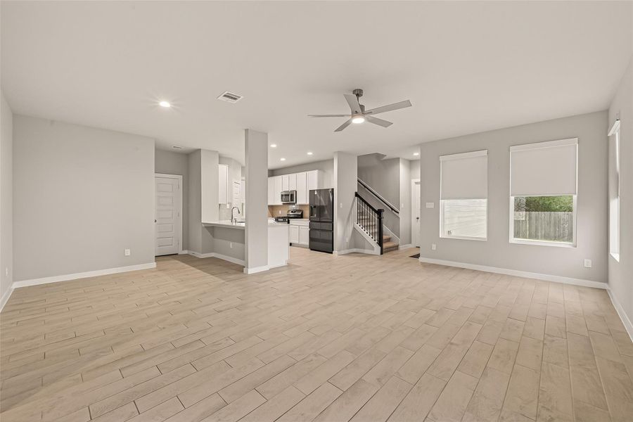 From this corner of the living room, you can take in the full view of the open layout that connects the living area, dining space, and kitchen.