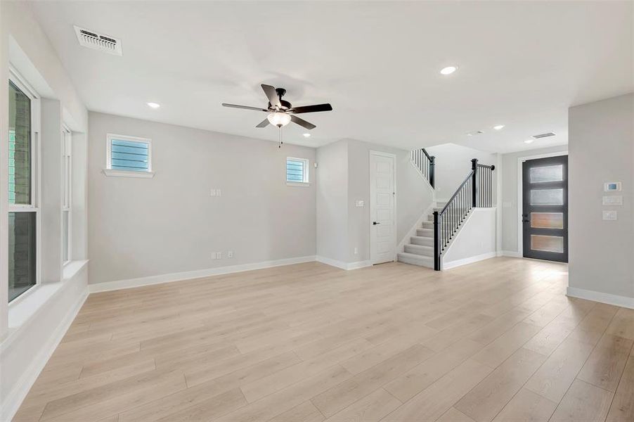 Unfurnished living room with light wood finished floors, a ceiling fan, and recessed lighting