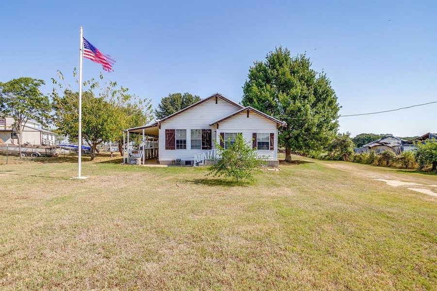 Back of property featuring a yard Back of property featuring a yard