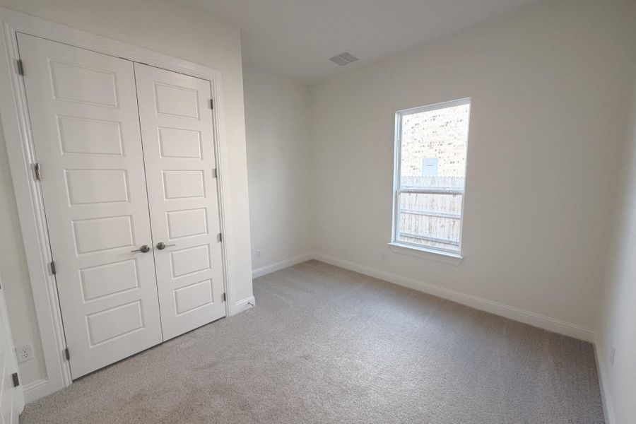 Unfurnished bedroom featuring a closet and light colored carpet