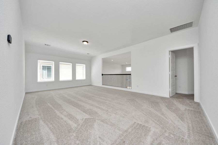 Ascend to relaxation in this fantastic game room! Ideal for both casual gatherings and adult gaming, it boasts plush carpet, lofty ceilings, custom paint, and ample windows for abundant natural light.