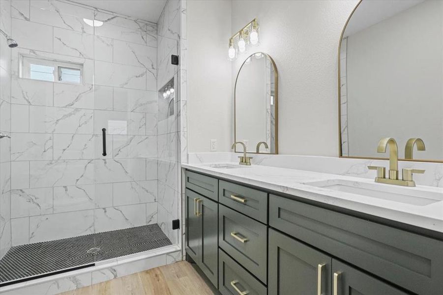 Bathroom with vanity, wood-type flooring, and a shower with door