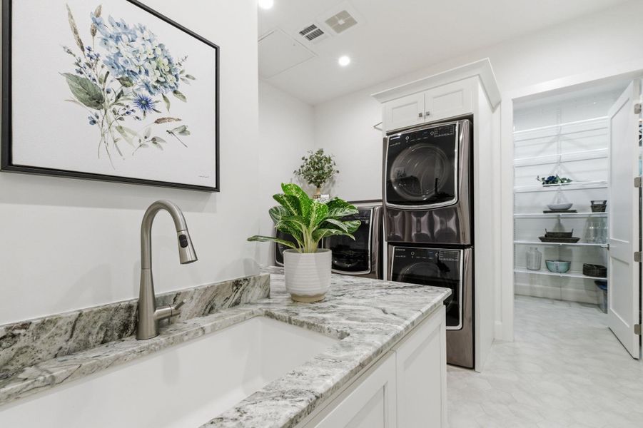 Laundry area featuring stacked washer / dryer and recessed lighting