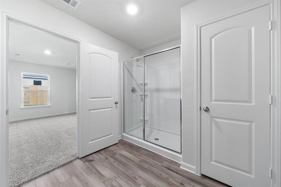 Bathroom featuring hardwood / wood-style flooring and a shower with door