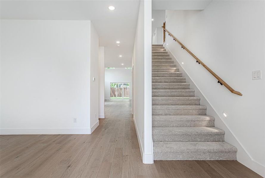 Stairway with wood finished floors, recessed lighting, and baseboards
