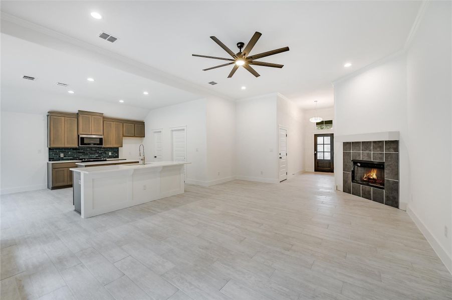 Kitchen with a sink, visible vents, open floor plan, tasteful backsplash, and stainless steel microwave