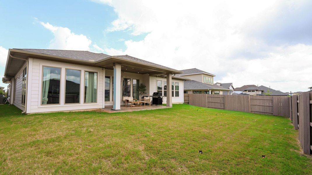 An inviting backyard oasis offers a covered patio ideal for outdoor relaxation and entertaining. An inviting backyard oasis offers a covered patio ideal for outdoor relaxation and entertaining.