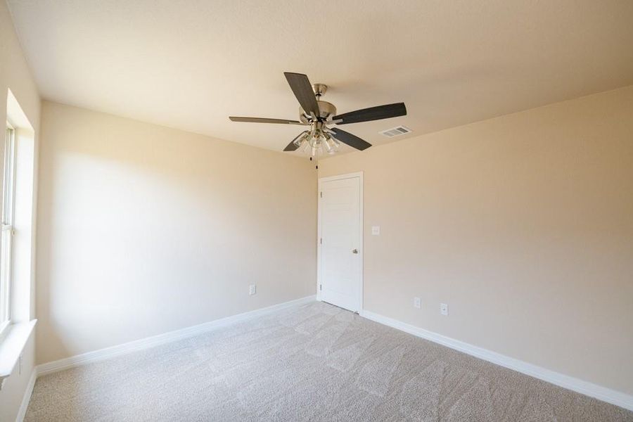 Carpeted spare room with baseboards and ceiling fan Carpeted spare room with baseboards and ceiling fan