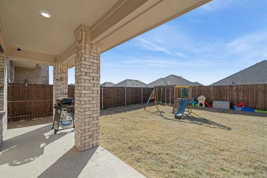 Fenced backyard featuring a playground and a patio Fenced backyard featuring a playground and a patio
