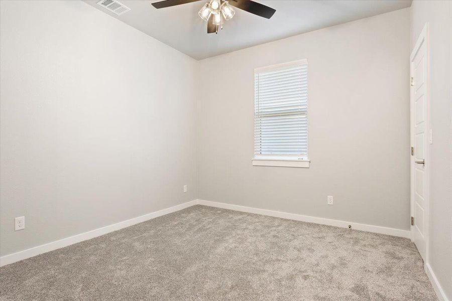 Empty room featuring light colored carpet and ceiling fan Empty room featuring light colored carpet and ceiling fan