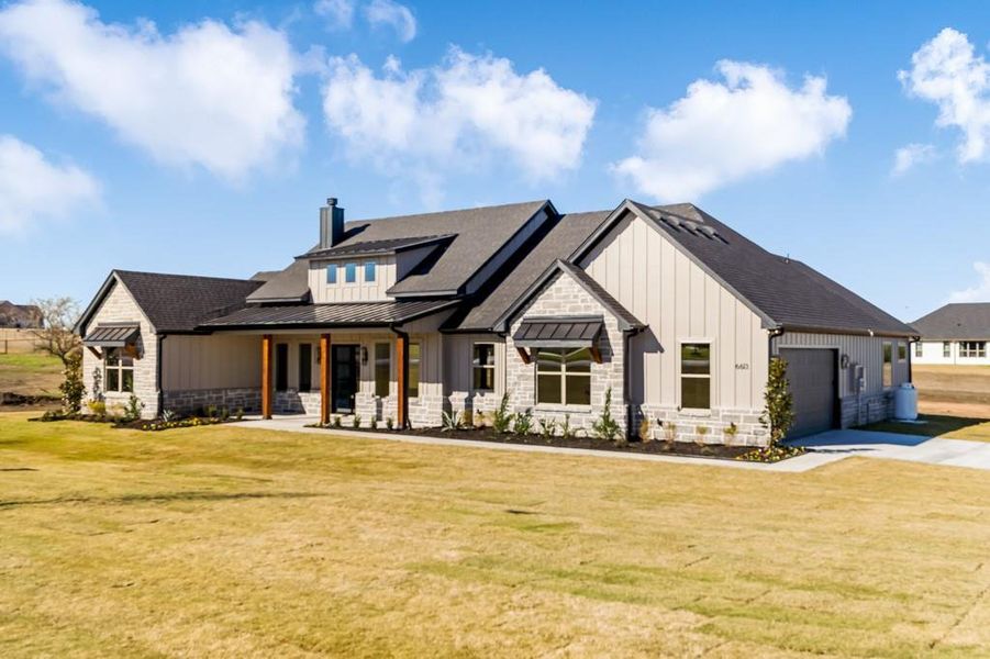 Modern inspired farmhouse featuring a front lawn, a porch, and a garage