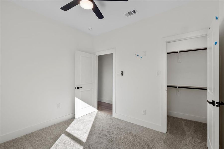 Unfurnished bedroom featuring ceiling fan, a closet, and carpet flooring