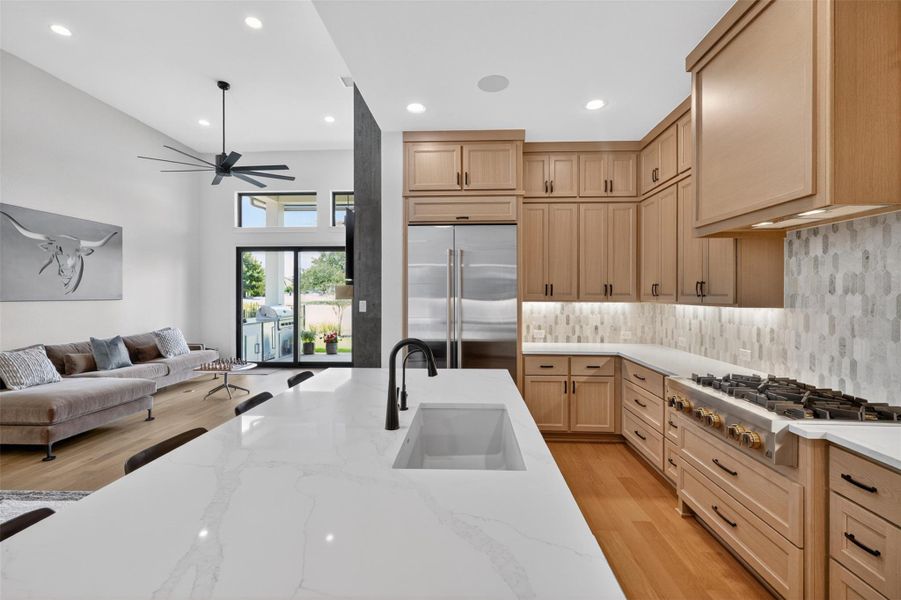 A striking kitchen with generous counter space flows into a luminous living area. A striking kitchen with generous counter space flows into a luminous living area.
