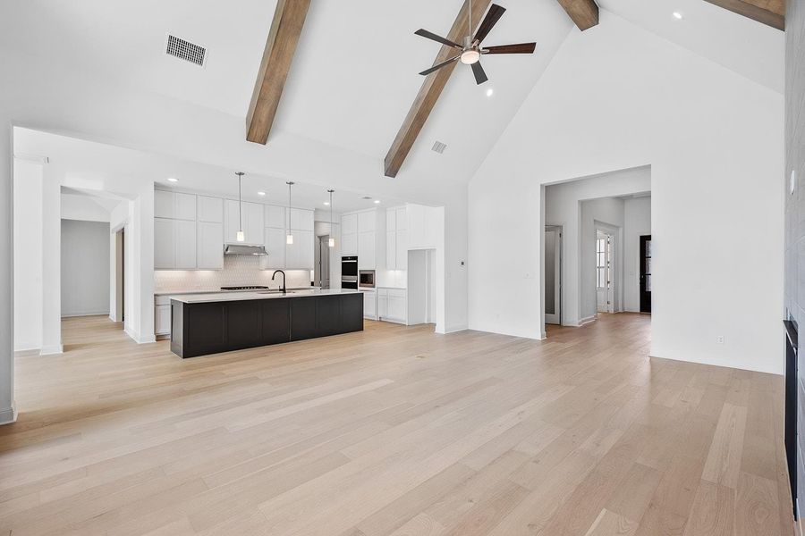 Living area featuring high vaulted ceiling, recessed lighting, beamed ceiling, ceiling fan, and light wood finished floors
