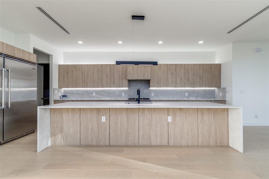 Kitchen with modern cabinets, stainless steel appliances, and built in fridge