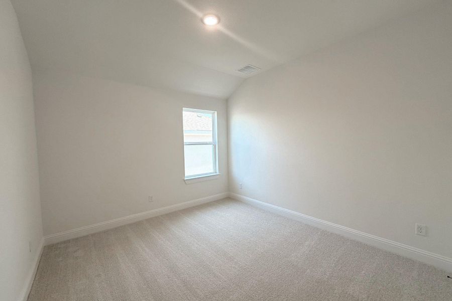 Carpeted room featuring a single window, recessed lighting, and a sloped ceiling