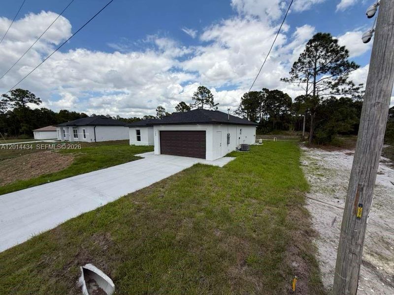 Front exterior of a new home in , Lehigh Acres, FL, highlighting curb appeal (Image 18).
