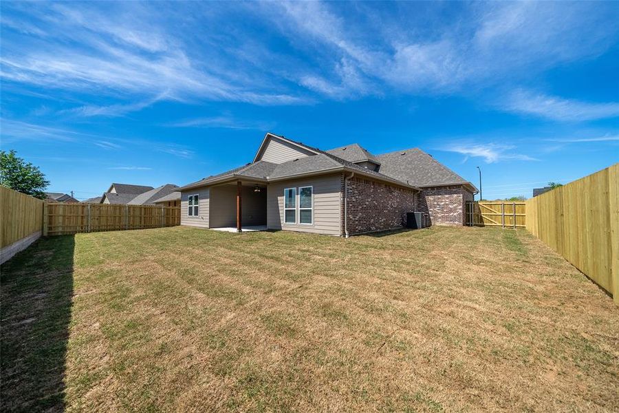 Rear view of property featuring a patio area, a fenced backyard, brick siding, and a shingled roof Rear view of property featuring a patio area, a fenced backyard, brick siding, and a shingled roof