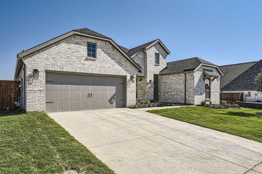 French country style house with a front yard and a garage