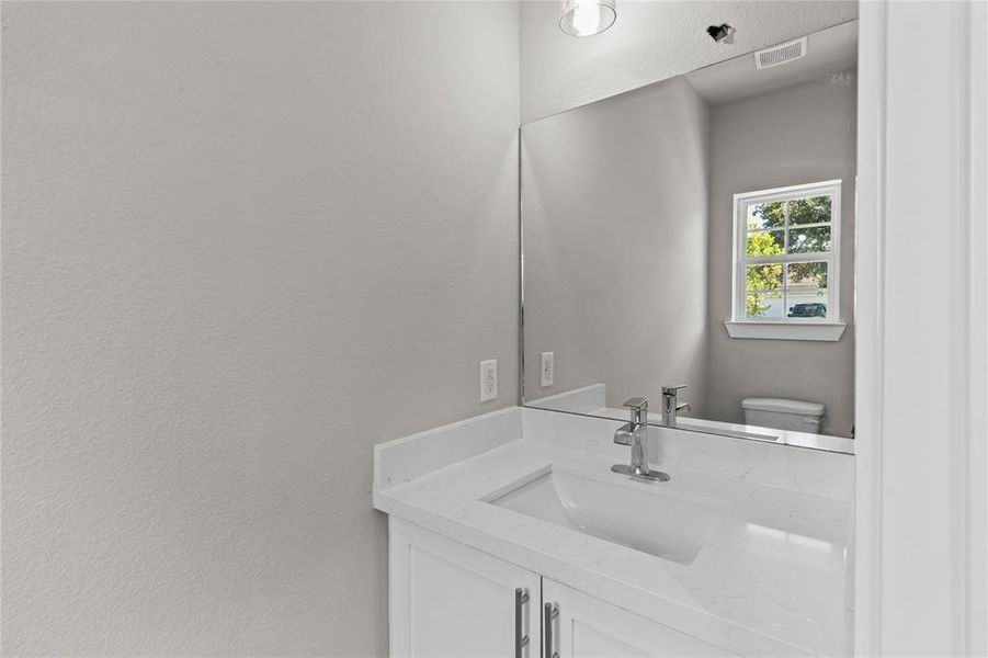 Modern and chic, this first-floor powder room is perfect for guests with its sleek design.