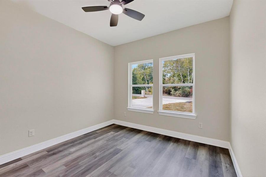 Unfurnished room featuring wood finished floors and a ceiling fan Unfurnished room featuring wood finished floors and a ceiling fan