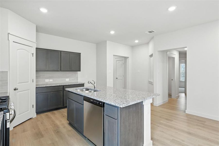 Kitchen with dishwasher, range with gas cooktop, decorative backsplash, light wood-style flooring, and recessed lighting