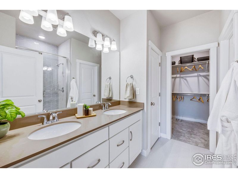 Primary bathroom w/ dual vanities and walk-in closet