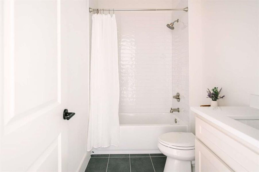 Full bathroom featuring toilet, tile patterned flooring, shower / bath combination with curtain, and vanity