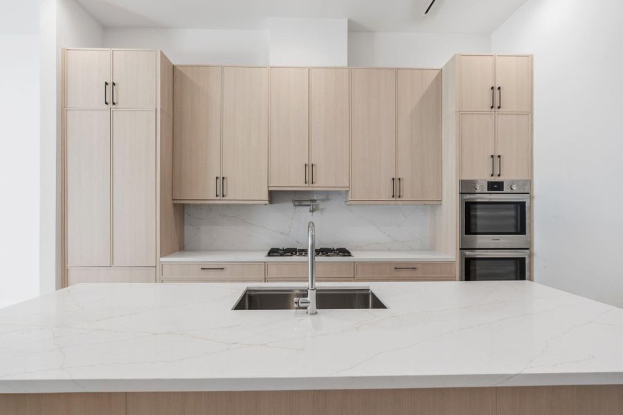 Bosch appliance suite includes double ovens, 36" gas cooktop with pot filler, and 36" integrated refrigerator.