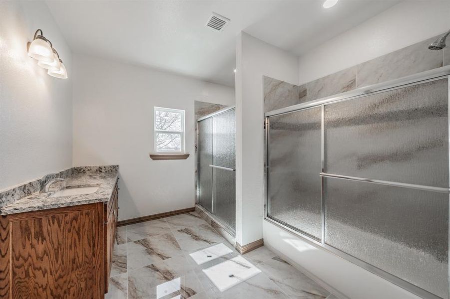 Bathroom with marble finish floor, visible vents, vanity, and baseboards