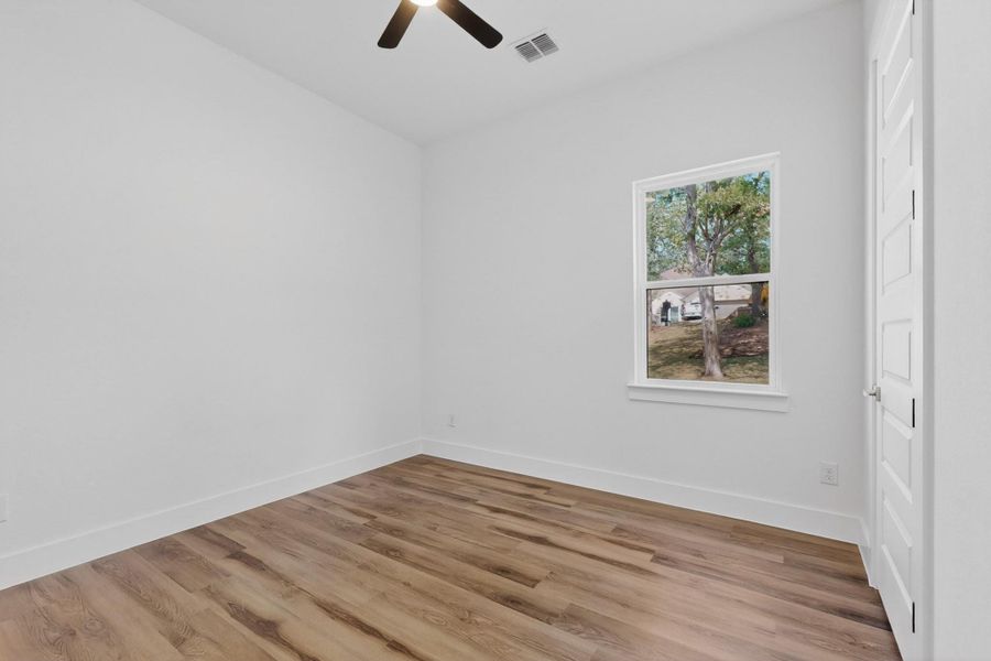 Well-lit room featuring durable wood flooring and a pleasant outdoor view.