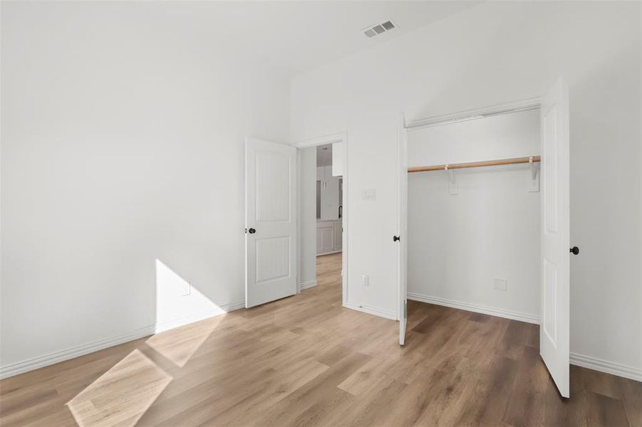 Unfurnished bedroom featuring hardwood / wood-style flooring and a closet