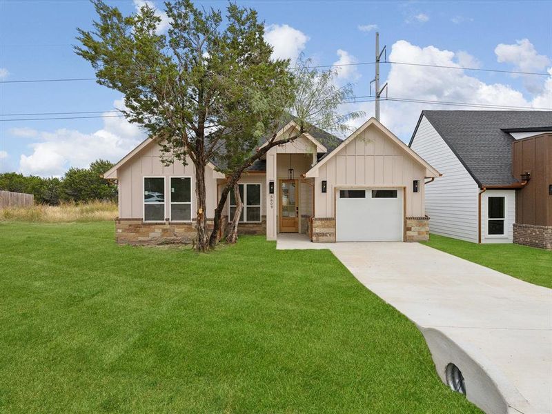 Modern farmhouse style home featuring a front lawn