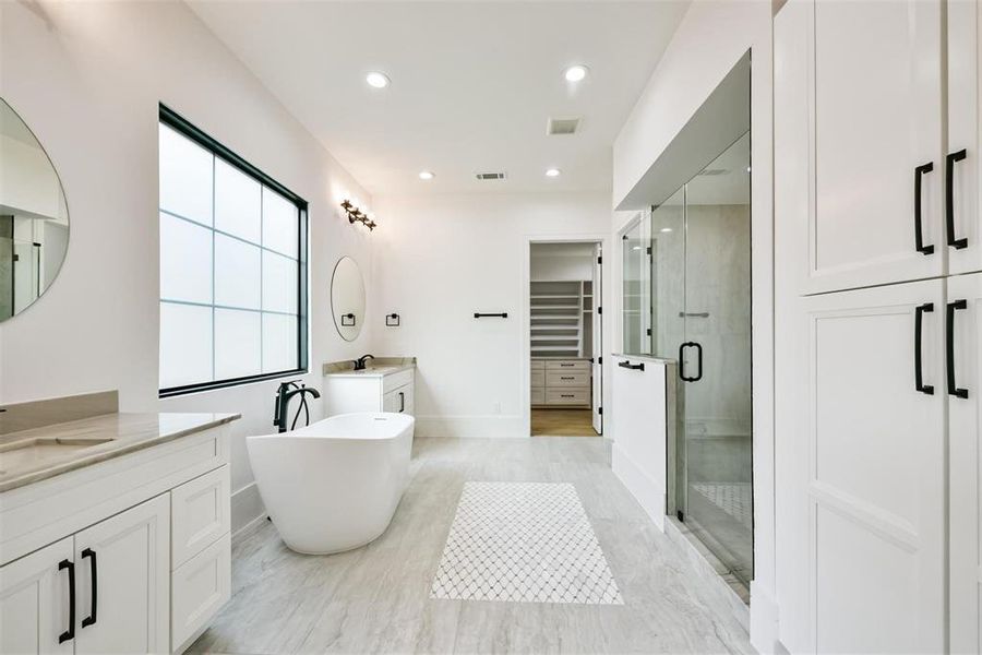 The Primary Bathroom boasts dual sink areas, a frameless shower, a freestanding bathtub, and additional luxurious touches throughout.