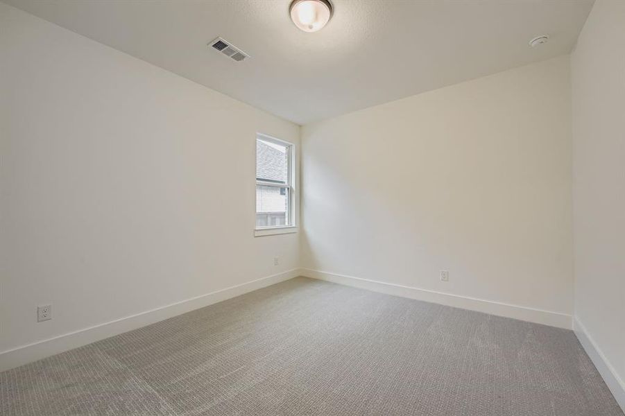 Carpeted spare room with baseboards