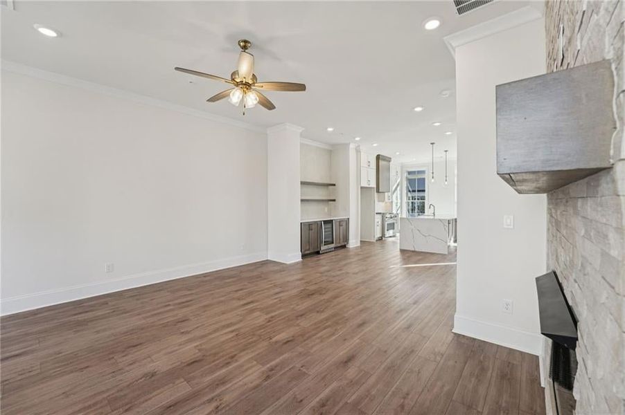 Family room space with stunning stone front fireplace surround in cream colored quartzite that runs all the up to the 10 foot ceiling height.  Other fireplaces and fireplace surrounds are selected for lots based on the design theme of each townhome.  Ima