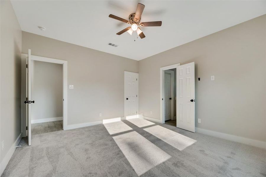 Unfurnished bedroom featuring light carpet and ceiling fan