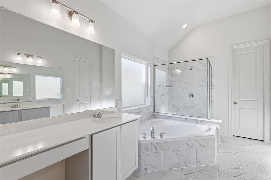 Full bath with a marble finish shower, light marble finish floors, vanity, a garden tub, and lofted ceiling Full bath with a marble finish shower, light marble finish floors, vanity, a garden tub, and lofted ceiling