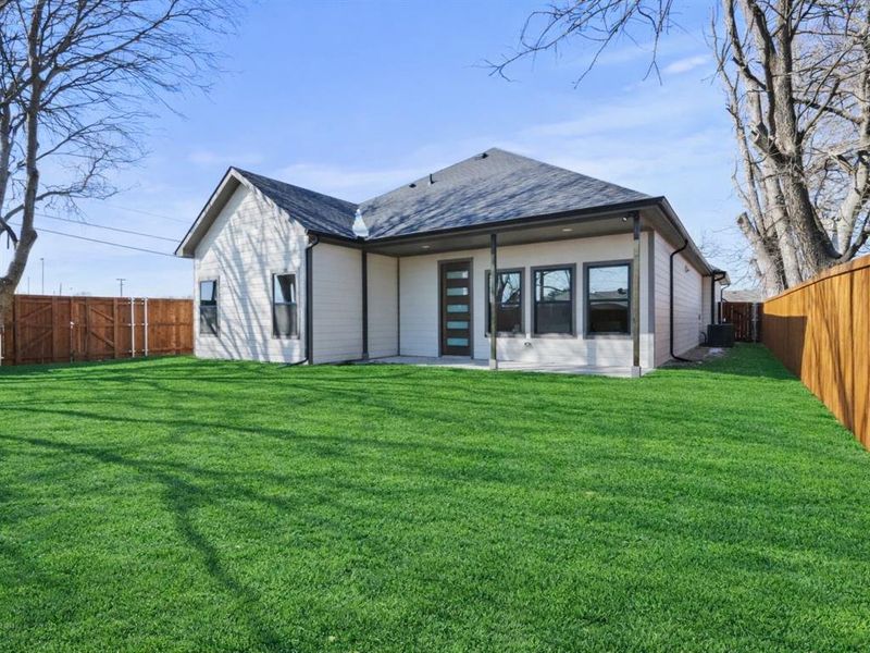 Back of property featuring a patio, a fenced backyard, and a shingled roof