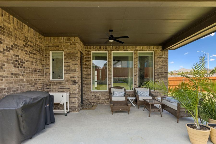 A spacious covered patio features classic brick walls and durable concrete flooring.
