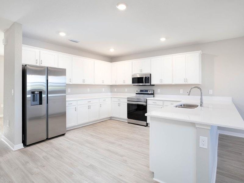 Your sunny kitchen offers ample cabinet and counter space, along with a large pantry - Wayfair III by Highland Homes Your sunny kitchen offers ample cabinet and counter space, along with a large pantry - Wayfair III by Highland Homes