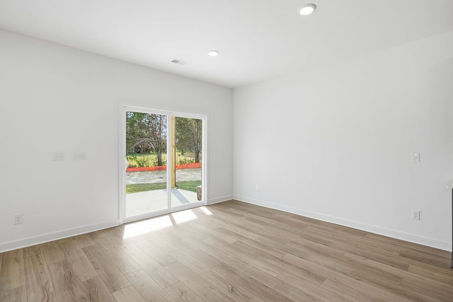 A room with a wood floor and a wood floor with a door. A room with a wood floor and a wood floor with a door.