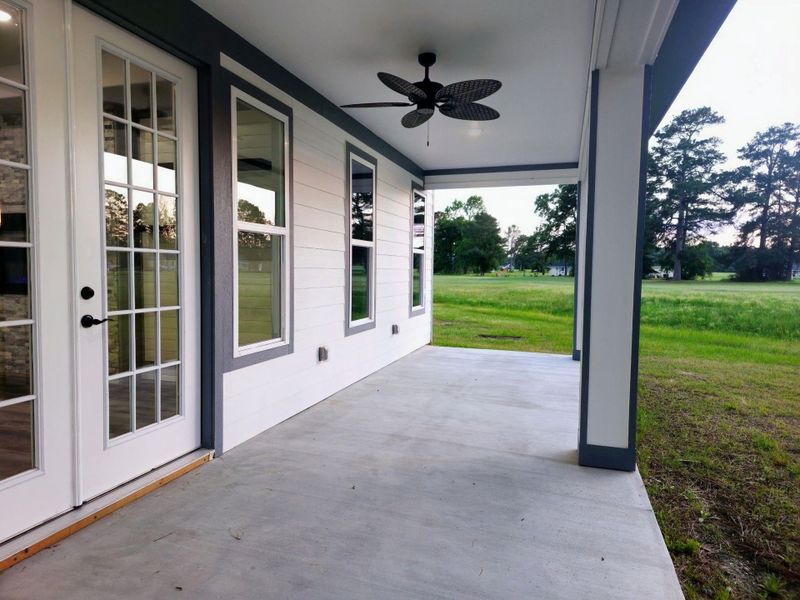 Covered patio with a ceiling fan, French doors, and a view of the golf course.